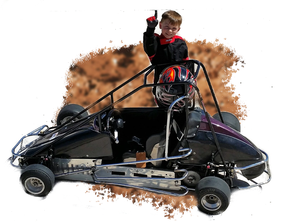 A person riding a go kart on top of dirt.