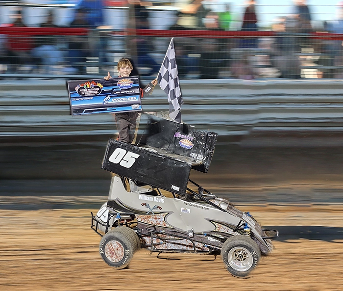 A person in a race car holding a checkered flag.