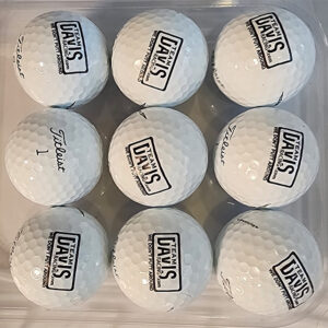 A close up of nine golf balls with logos