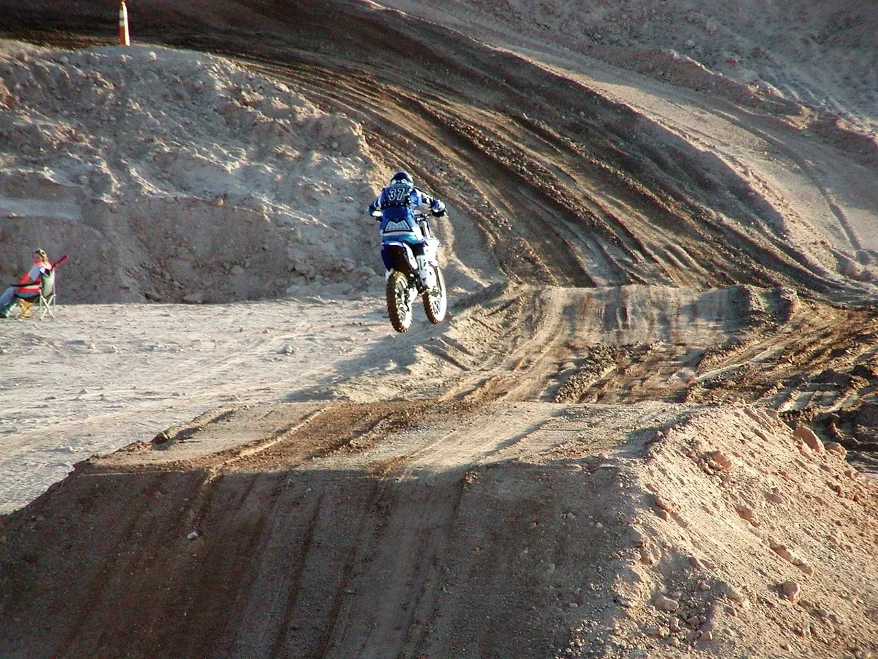 A person on a dirt bike riding up the side of a hill.