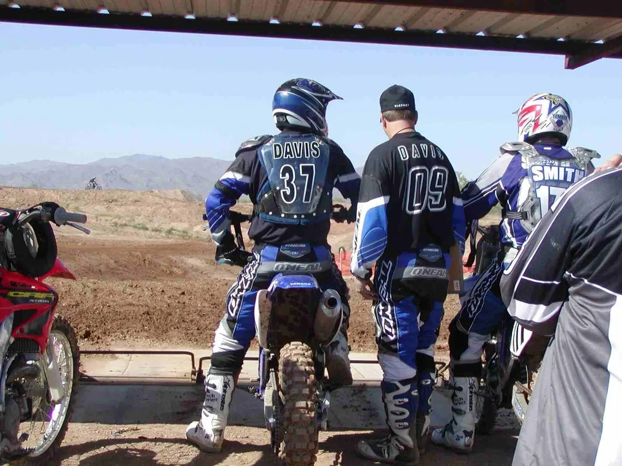 A group of people on motorcycles in the dirt.