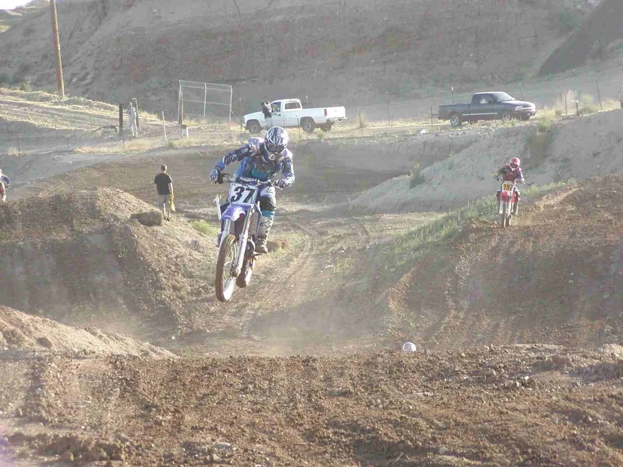 A person on a dirt bike riding over a hill.