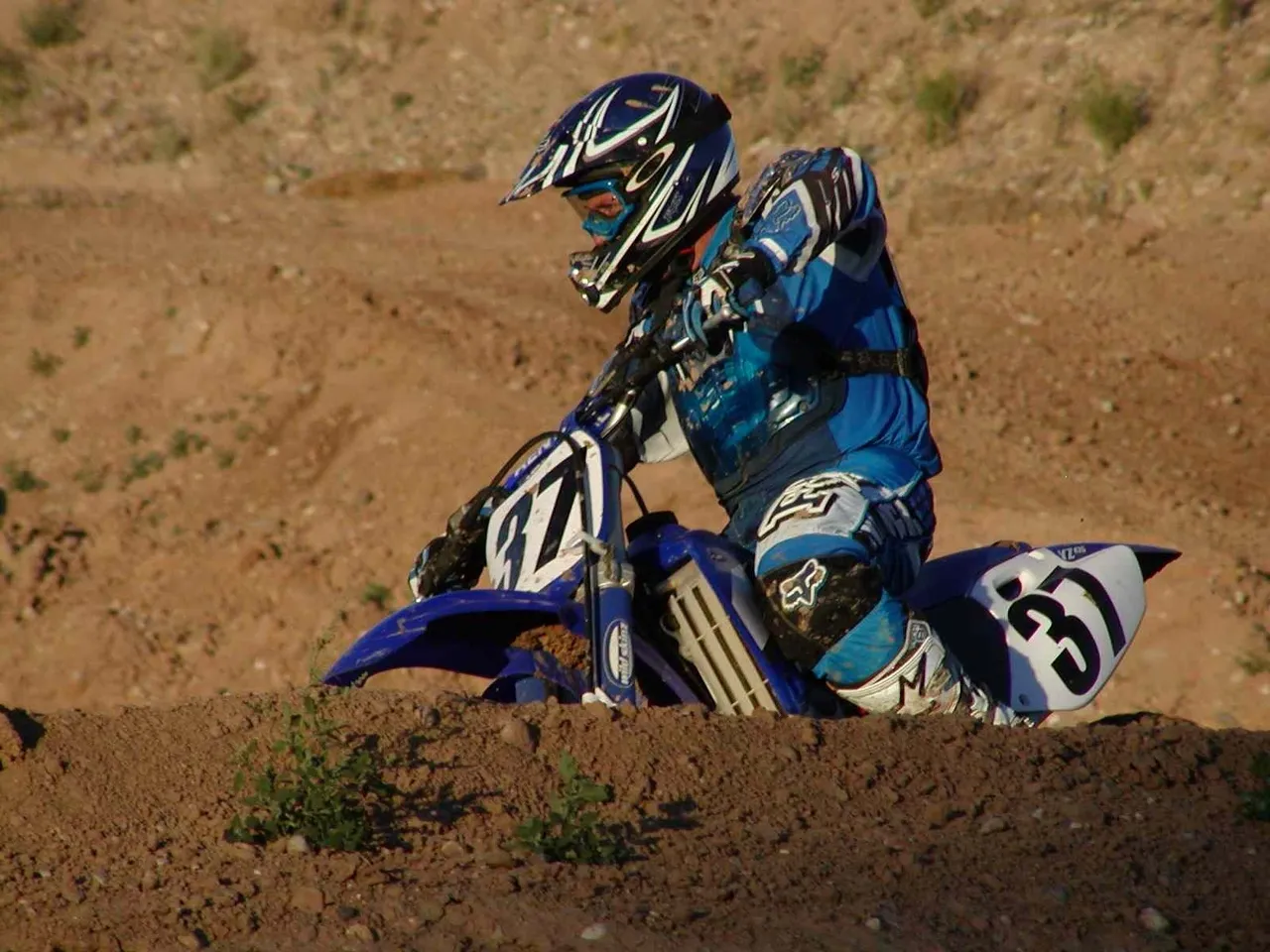 A person on a dirt bike in the sand.