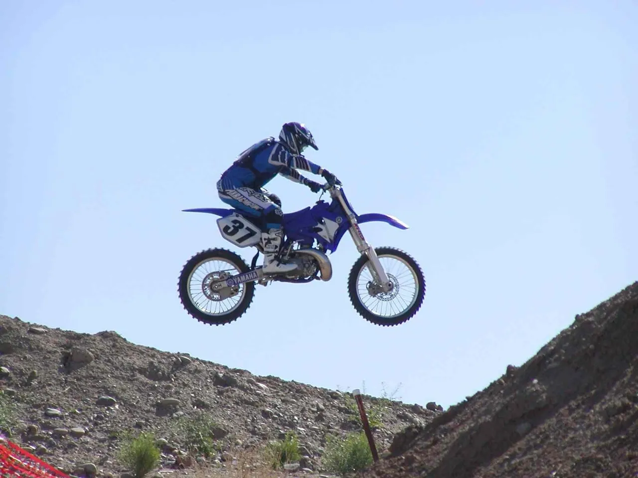 A person on a motorcycle jumping over some rocks