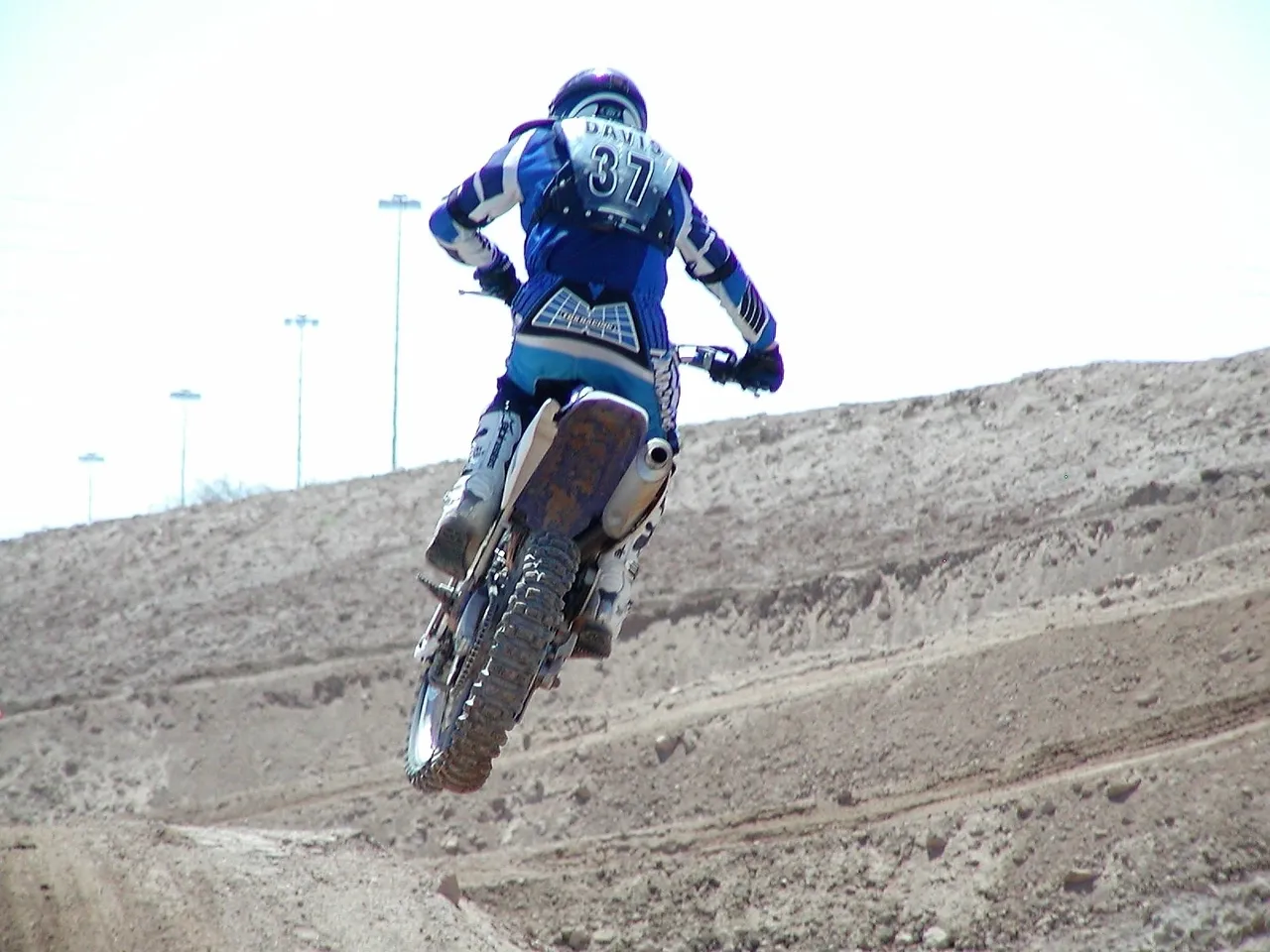 A person on a dirt bike jumping over some sand.