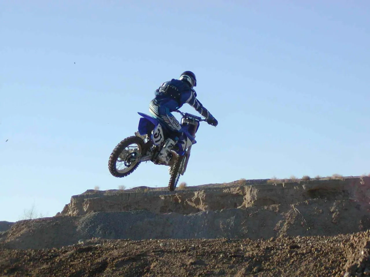 A person on a motorcycle jumping over rocks.